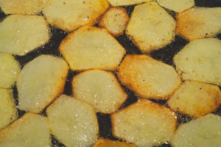 Roasted sliced potato in frying process. food backgroundの写真素材
