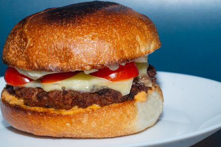 Homemade cheeseburger close up. beef meat with tomato and cheeseの写真素材