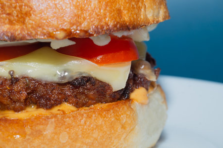 Homemade cheeseburger close up. beef meat with tomato and cheeseの写真素材