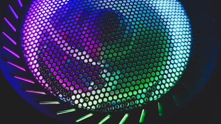 Colorful led lights of computer fan shines through the protective grid. illumination glows in the dark. abstract futuristic backgroundの写真素材