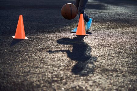 sports equipment in the form of a cone for training in the gym or outdoors.Orange cones on a dark surface. Soccer practice. Sports training and lessons for children and adultsの写真素材
