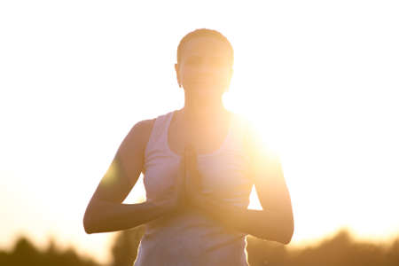 silhouette of a woman doing yoga in the fresh air. The concept of a healthy lifestyle. Outdoor recreation. Meditation and yoga classesの写真素材