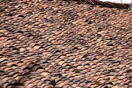 many old brown tiles on the roof of the homeの写真素材