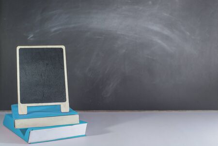 Blue books and Mini blackboard placed on the table, Blackboard as a backdrop, Copy-spaceの写真素材