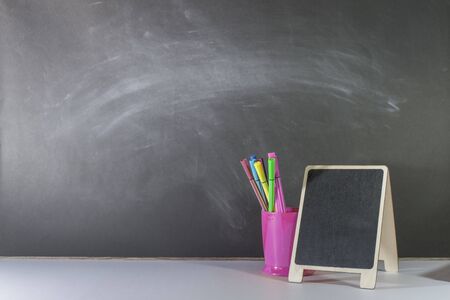 Mini blackboard and stationery are placed on the table, Blackboard wall, Back to school concept, Copy-spaceの写真素材
