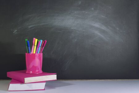 Books and stationery are placed on the table, Blackboard wall, Back to school concept, Copy-spaceの写真素材