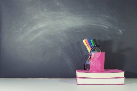 Books and stationery are placed on the table, Blackboard wall, Back to school concept, Copy-spaceの写真素材