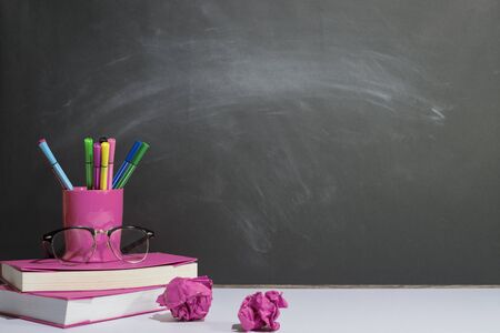 Books and stationery are placed on the table, Blackboard wall, Back to school concept, Copy-spaceの写真素材