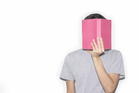 Man wearing a gray T-shirt holds his book off his face, On a white background, Copy-spaceの写真素材