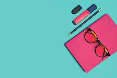 Glasses, book and stationery placed on blue background, Back to school concept, Copy-spaceの写真素材