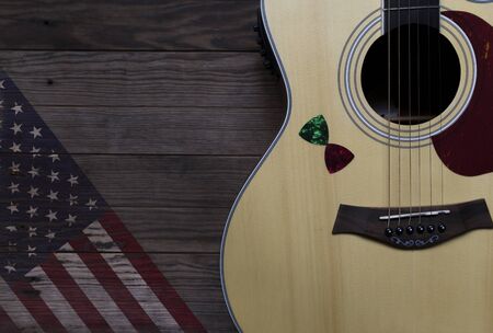 Acoustic guitar placed on an old wooden table, With a picture of an American flag on wood, Close-upの写真素材