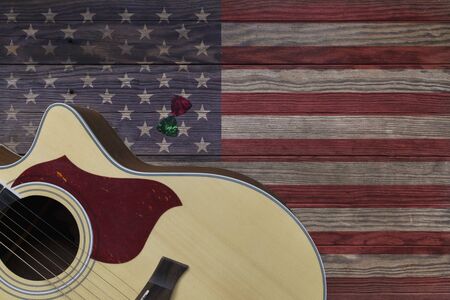 Acoustic guitar placed on an old wooden table, With a picture of an American flag on wood, Close-upの写真素材