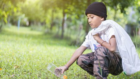 Boy sitting to collect plastic bottles in the park, Copy-spaceの写真素材