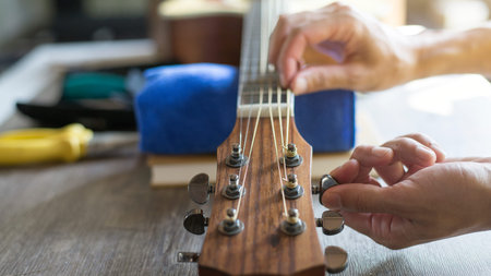 Checking the acoustic guitar string, Expert is tuning the guitar string, Close-up