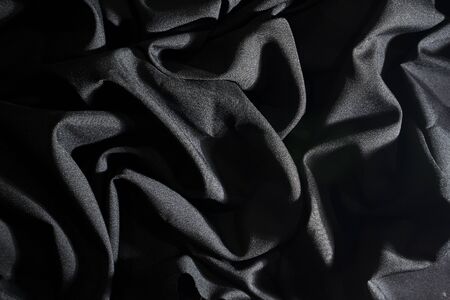 Wrinkle black fabric texture, And incident light, Dark background.の写真素材