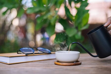 Garden reading table, Hand is pouring tea into the teacup, Close-upの写真素材