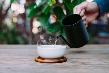 Rustic morning tea, Pouring tea onto the teacup, Close-upの写真素材