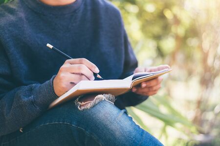 Man writing a note in the park, Close-up, Copy-space.の写真素材