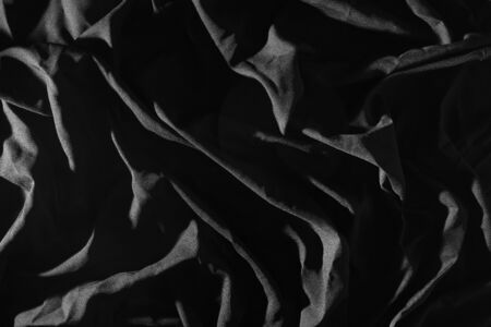 Crumpled cloth in black, Light causes patterns.の写真素材