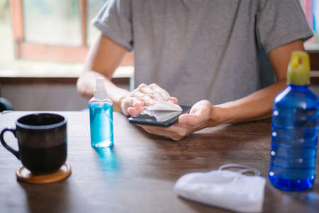 Coronavirus protection concept, Cleaning smartphone with alcohol, Close-up.の写真素材