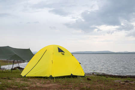 Camping on the island, Yellow tent on the shore by the sea.の写真素材