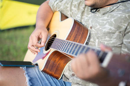 Man playing acoustic guitar, Focus on acoustic guitar body, Close-upの写真素材