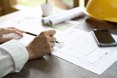Architect's desk, Architects are analyzing the house structure, Focus on the hand, Close up.の写真素材