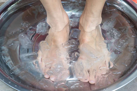 Foot care after injury, Soak your feet in cold water.の写真素材