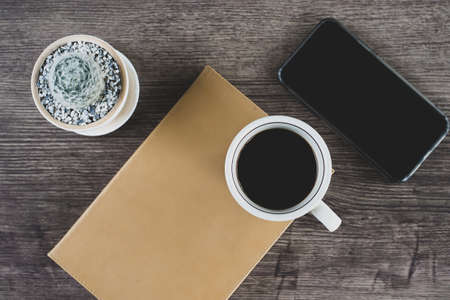 Book, cactus and coffee cup placed on a wooden table, Top view.の写真素材