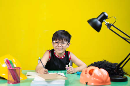 Happy children wearing glasses doing homework, Learning equipment on the table.の写真素材