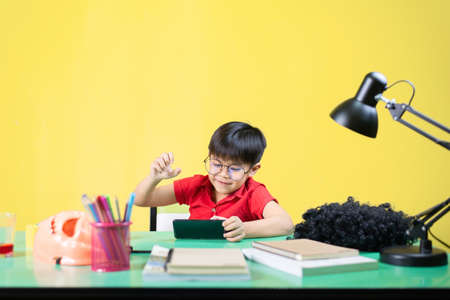 Boy playing smart phone games, Fun expression, At his desk.の写真素材