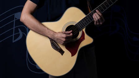 Musician with an acoustic guitar in the dark, Night photo with side lighting.の写真素材