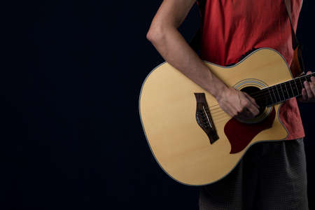 Musician wearing red shirts playing acoustic guitar in the dark, Copy space.の写真素材