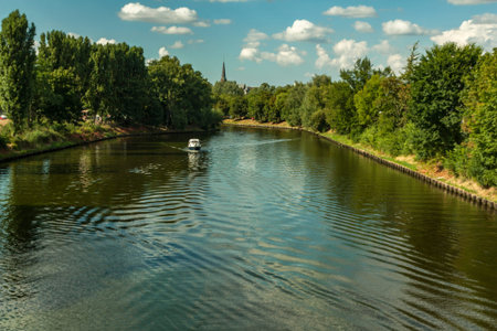boattrip on an sunny day with a church spire in the backround and on both side of the river are...