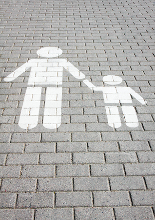 Sign pedestrian crossing painted on the road, safety of children - adult holds the child by the handの写真素材
