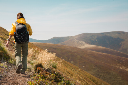 Mountain hiking tourism. Woman hiker  summer day in a beautiful landscape alone. Relaxation and solitude, active lifestyleの写真素材