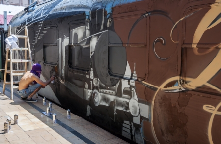 Bucharest, Romania - June 29, 2013:  A young graffiti artist during drawing and painting his artwork in Train Delivery Fest on 29 June, 2013 in Bucharest, Romaniaのeditorial素材