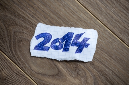 New Year written on piece of paper, on a wood background.の写真素材