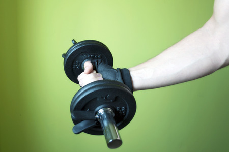 Arm of man a lifting weights isolated on a green の写真素材