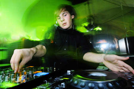 Dj mixes the track in the nightclub at party