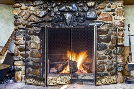 Stone fireplace in country house and fire blazing inside with natural lightの写真素材