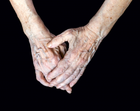 Close up of elderly female hands on black backgroundの写真素材