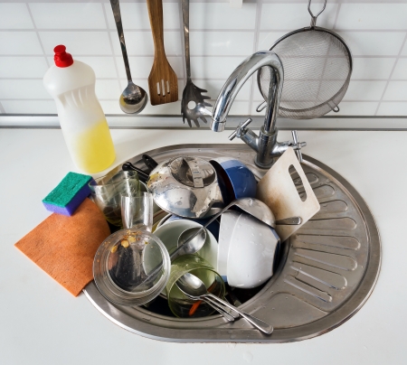 Pile of dirty dishes in the sink stainless steelの写真素材