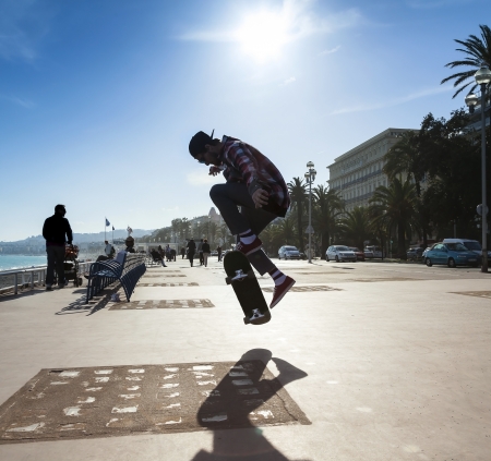 Silhouette of Skateboarder jumping in city on background of promenade and seaのeditorial素材