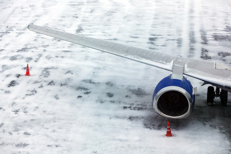 Wing of passenger aircraft closeup at the airport in winter before takeoffの写真素材