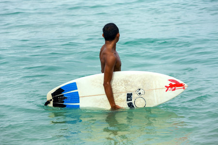 Man holding surf board standing in the ocean