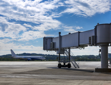 Passenger airplane on the runway in motion  In the foreground is a  sleeve transition for boarding passengers in aircraftのeditorial素材