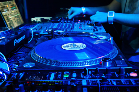Dj mixes the track in the nightclub at party. Vinyl Player in foregroundのeditorial素材