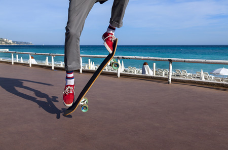 Skateboarder jumping in city on background of promenade and seaの写真素材