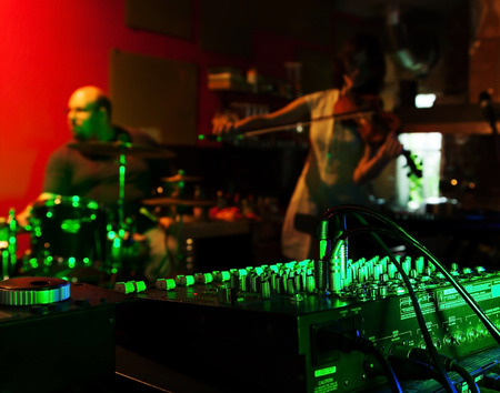 Music Mixer at nightclub with connected wires. In the background, the musicians play live musicのeditorial素材
